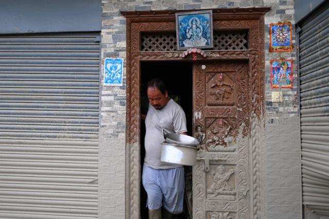 A man salvages his belongings from inside his house heavily covered in mud in the aftermath of flash floods at Devighat in Nepal's Nuwakot district on August 29, 2026. Nearly 3,000 people were still missing on August 29 and 633 confirmed dead after flash floods and landslides hit the Nepal-Tibet border. (Photo by Manan VATSYAYANA / AFP)
