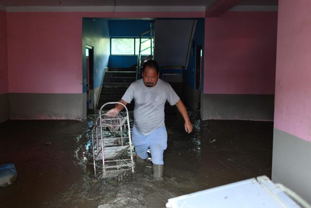 A man salvages his belongings from inside his house heavily covered in mud in the aftermath of flash floods at Devighat in Nepal's Nuwakot district on August 29, 2026. Nearly 3,000 people were still missing on August 29 and 633 confirmed dead after flash floods and landslides hit the Nepal-Tibet border. (Photo by Manan VATSYAYANA / AFP)