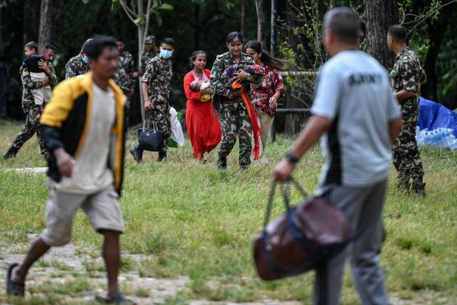 Army personnel carry rescued infants in the aftermath of flash floods at Trishuli camp in Nepal's Nuwakot district on August 29, 2026. Nearly 3,000 people were still missing on August 29 and 633 confirmed dead after flash floods and landslides hit the Nepal-Tibet border. (Photo by Arun SANKAR / AFP)
