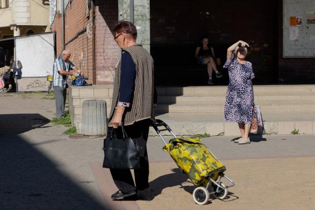 Pedestrians walk down a street in Berehove on August 28, 2026, amid the Russian invasion of Ukraine. (Photo by Tetiana DZHAFAROVA / AFP)