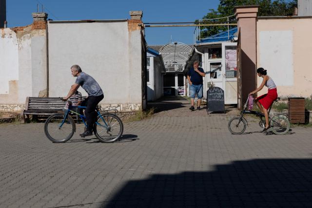 Cyclists pedal down the street in Berehove on August 28, 2026, amid the Russian invasion of Ukraine. (Photo by Tetiana DZHAFAROVA / AFP)