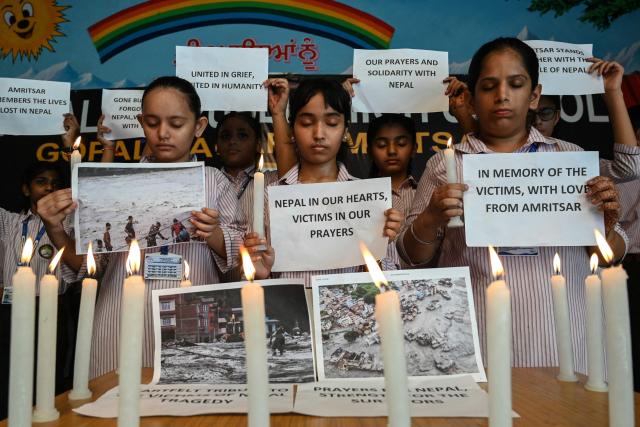Students holding candles pay homage to people who died in Nepal's flash floods, in Amritsar on August 29, 2026. Nearly 3,000 people were still missing on August 29 and 633 confirmed dead after flash floods and landslides hit the Nepal-Tibet border. (Photo by Narinder NANU / AFP)