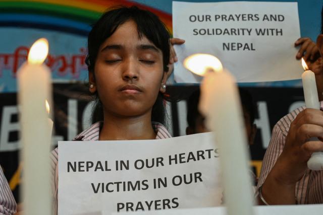 A student holding a placard pays homage to people who died in Nepal's flash floods, in Amritsar on August 29, 2026. (Photo by Narinder NANU / AFP)