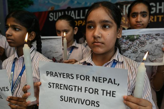 Students holding candles pay homage to people who died in Nepal's flash floods, in Amritsar on August 29, 2026. Nearly 3,000 people were still missing on August 29 and 633 confirmed dead after flash floods and landslides hit the Nepal-Tibet border. (Photo by Narinder NANU / AFP)