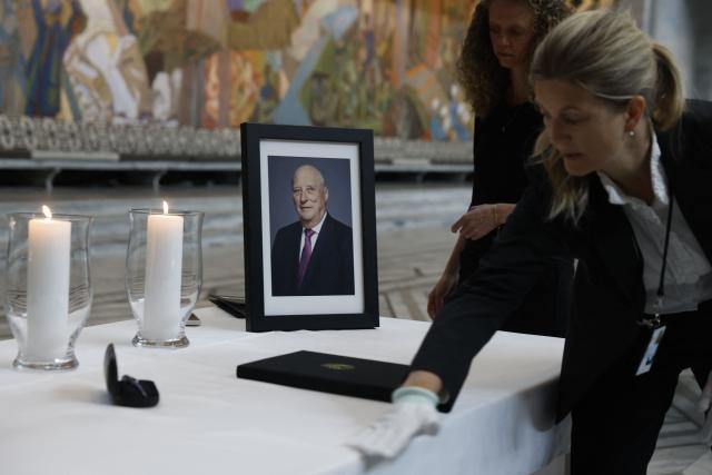 A table displaying a portrait of the late King is being set up inside Oslo City Hall in Oslo on August 29, 2026, for members of the public wishing to sign condolence books following his death. King Harald V of Norway, who died on August 28, 2026 aged 89, remained a unifying figure in his country until the very end, a pillar of stability amid a string of family scandals that tarnished the final years of his reign. (Photo by Odd ANDERSEN / AFP)