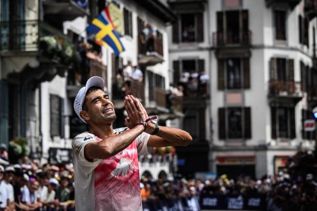 US trail runner Ben Dhiman celebrates as he crosses the finish line to win the 23rd edition of the Ultra Trail du Mont Blanc (UTMB), a 174km trail race crossing France, Italy and Switzerland, in Chamonix, south-eastern France on August 29, 2026. Runner-up in 2025, Dhiman took control of the race as soon as he left Les Contamines (around the 35 km mark), before launching into an irresistible solo performance, greatly helped by particularly favorable weather conditions this year. He completed his effort in 18 h 16 min 29 sec, far ahead of the other competitors. (Photo by JEFF PACHOUD / AFP)