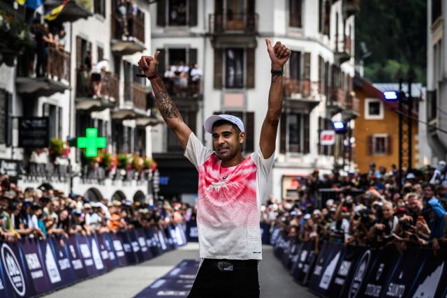US trail runner Ben Dhiman celebrates as he crosses the finish line to win the 23rd edition of the Ultra Trail du Mont Blanc (UTMB), a 174km trail race crossing France, Italy and Switzerland, in Chamonix, south-eastern France on August 29, 2026. Runner-up in 2025, Dhiman took control of the race as soon as he left Les Contamines (around the 35 km mark), before launching into an irresistible solo performance, greatly helped by particularly favorable weather conditions this year. He completed his effort in 18 h 16 min 29 sec, far ahead of the other competitors. (Photo by JEFF PACHOUD / AFP)