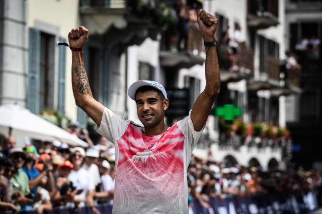 US trail runner Ben Dhiman celebrates as he crosses the finish line to win the 23rd edition of the Ultra Trail du Mont Blanc (UTMB), a 174km trail race crossing France, Italy and Switzerland, in Chamonix, south-eastern France on August 29, 2026. Runner-up in 2025, Dhiman took control of the race as soon as he left Les Contamines (around the 35 km mark), before launching into an irresistible solo performance, greatly helped by particularly favorable weather conditions this year. He completed his effort in 18 h 16 min 29 sec, far ahead of the other competitors. (Photo by JEFF PACHOUD / AFP)