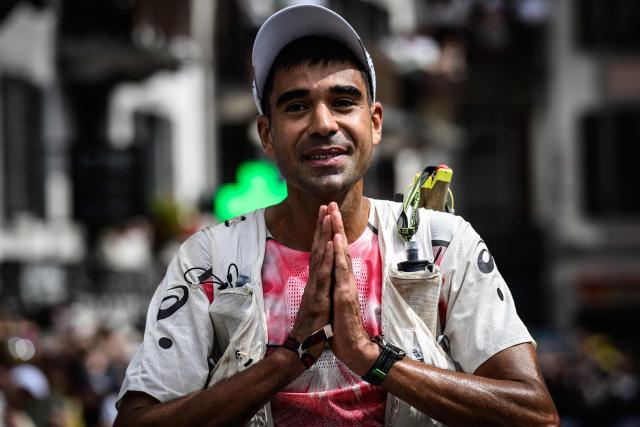 US trail runner Ben Dhiman celebrates as he crosses the finish line to win the 23rd edition of the Ultra Trail du Mont Blanc (UTMB), a 174km trail race crossing France, Italy and Switzerland, in Chamonix, south-eastern France on August 29, 2026. Runner-up in 2025, Dhiman took control of the race as soon as he left Les Contamines (around the 35 km mark), before launching into an irresistible solo performance, greatly helped by particularly favorable weather conditions this year. He completed his effort in 18 h 16 min 29 sec, far ahead of the other competitors. (Photo by JEFF PACHOUD / AFP)