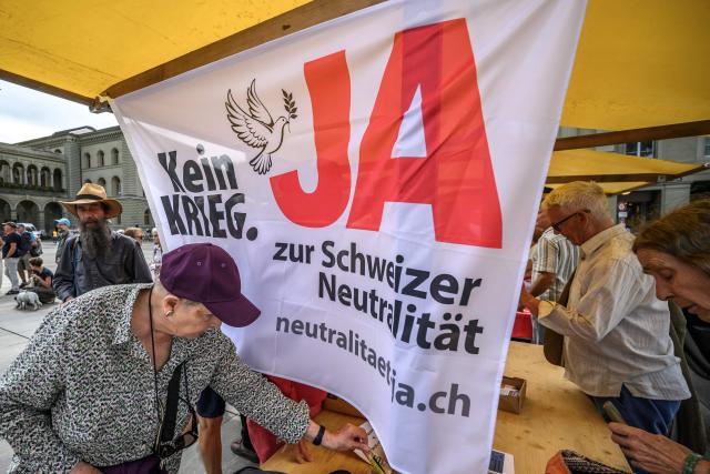 An electoral poster reading in German 'No war, Yes to Swiss neutrality' is displayed at a stand during a demonstration by supporters of the 'Safeguarding Swiss Neutrality' popular initiative on Federal Square ahead of a nationwide vote, in Bern, on August 29, 2026. On September 27, 2026, Swiss citizens will vote on a popular initiative seeking to enshrine Switzerlands perpetual and armed neutrality in the Federal Constitution and limit participation in military alliances and sanctions against belligerent states. (Photo by Fabrice COFFRINI / AFP)