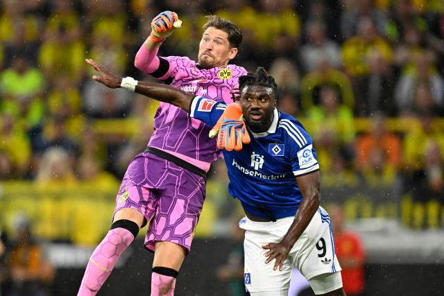 Dortmund's Swiss goalkeeper #01 Gregor Kobel clears the ball over Hamburg's Nigerian forward #09 Terem Moffi vie for the ball during the German first division Bundesliga football match between BVB Borussia Dortmund and Hamburg SV in Dortmund, western Germany on August 29, 2026. (Photo by INA FASSBENDER / AFP) / DFL REGULATIONS PROHIBIT ANY USE OF PHOTOGRAPHS AS IMAGE SEQUENCES AND/OR QUASI-VIDEO