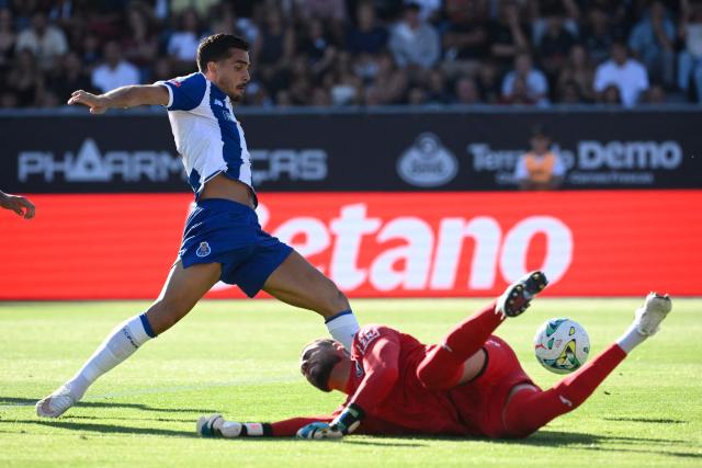 FC Porto's Portuguese forward #19 Andre Silva scores his team's first goal past Academico de Viseu's Brazilian goalkeeper #98 Ewerton (R) during the Portuguese League football match between Academico de Viseu F.C. and FC Porto at Estadio Municipal de Fontelo in Viseu on August 29, 2026. (Photo by Miguel RIOPA / AFP)