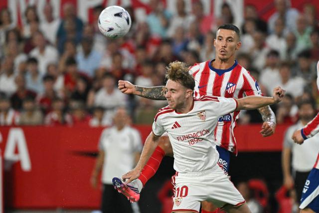 Sevilla's Spanish forward #10 Gerard Peque (L) vies for the ball with Atletico Madrid's Spanish defender #22 Alejandro Grimaldo during the Spanish league football match between Sevilla FC and Club Atletico de Madrid at the Ramon Sanchez Pizjuan stadium in Seville on August 29, 2026. (Photo by JORGE GUERRERO / AFP)