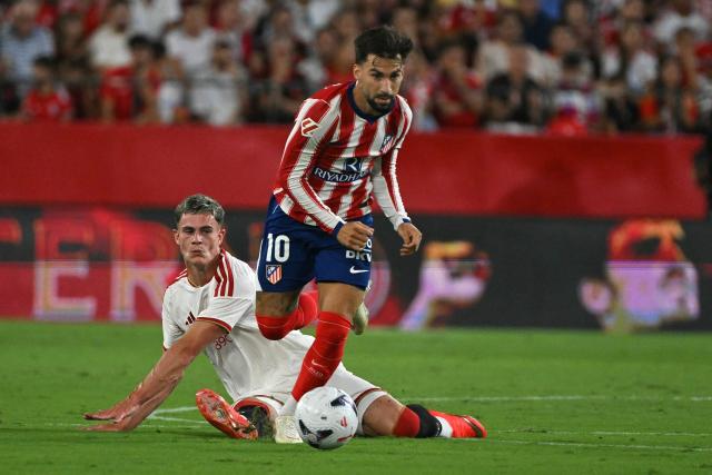 Atletico Madrid's Spanish forward #10 Alex Baena (R) runs with the ball in front of Sevilla's Scottish forward #09 Robbie Ure during the Spanish league football match between Sevilla FC and Club Atletico de Madrid at the Ramon Sanchez Pizjuan stadium in Seville on August 29, 2026. (Photo by JORGE GUERRERO / AFP)