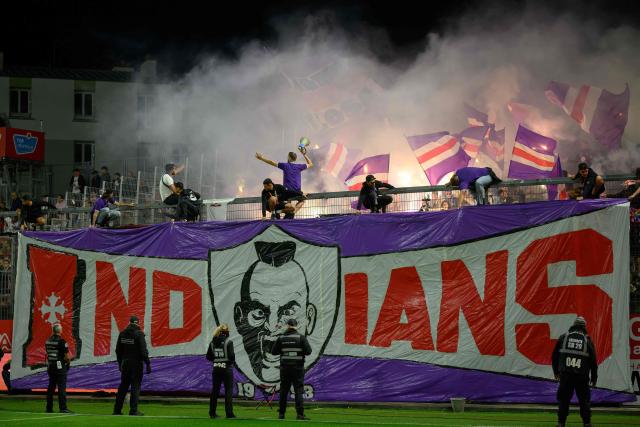 Toulouse's supporters display a tifo reading "Indians" and hold lit flares as they cheer for their team during the French L1 football match between Stade Brestois 29 and Toulouse Football Club at the Francis Le Ble stadium in Brest, western France on August 29, 2026. (Photo by Loic VENANCE / AFP)