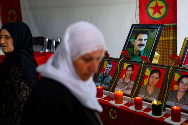 Relatives look at photographs during funeral commemorations of PKK guerrillas who had died as Kurdish families gathered to honor relatives killed in the conflict, in the Kucukcekmece district of Istanbul, on August 29, 2026. With the Turkish Parliament's adoption in mid-August of the Law on the Reintegration of Kurdish Fighters into Civilian Life, following twenty months of peace talks, the lists of "martyrs" are being gradually published by the authorities. (Photo by Yasin AKGUL / AFP)