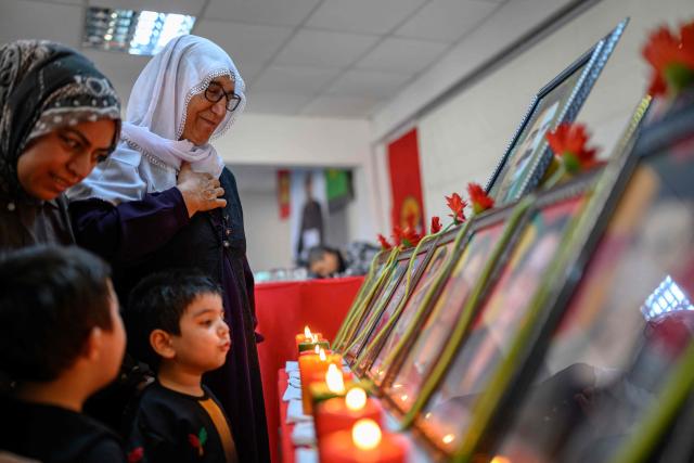 Relatives look at photographs during funeral commemorations of PKK guerrillas who had died as Kurdish families gathered to honor relatives killed in the conflict, in the Kucukcekmece district of Istanbul, on August 29, 2026. With the Turkish Parliament's adoption in mid-August of the Law on the Reintegration of Kurdish Fighters into Civilian Life, following twenty months of peace talks, the lists of "martyrs" are being gradually published by the authorities. (Photo by Yasin AKGUL / AFP)