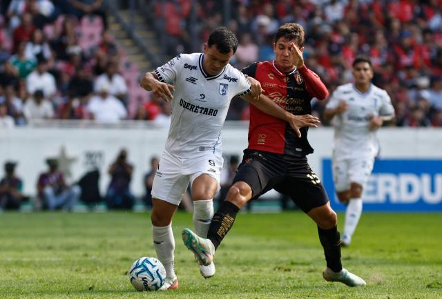 Queretaro's forward #09 Ali Avila and Atlas' defender #15 Paulo Ramirez fight for the ball during the Liga MX Apertura tournament football match between Atlas and Queretaro, at the Jalisco stadium in Guadalajara, state of Jalisco, Mexico, on August 29, 2026. (Photo by ULISES RUIZ / AFP)