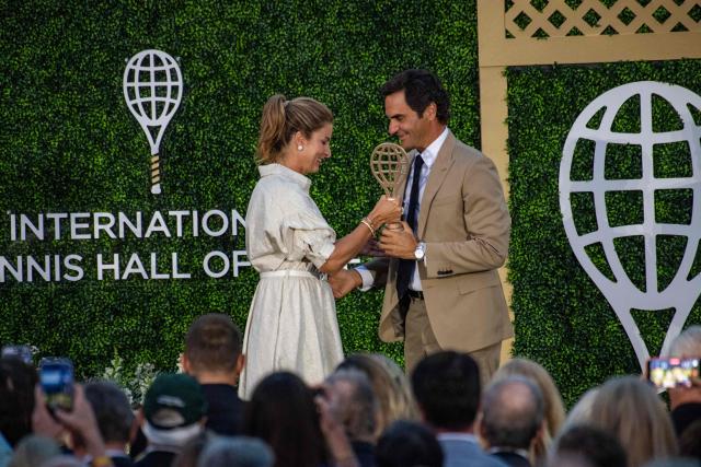 Mirka Federer presents the hall of fame trophy racket to Swiss former tennis player Roger Federer as he is inducted into the International Tennis Hall of Fame during a ceremony in Newport, Rhode Island, on August 29, 2026. (Photo by Joseph Prezioso / AFP)