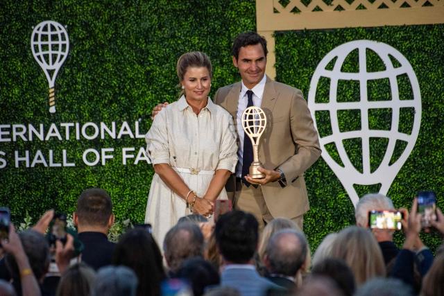 Mirka Federer presents the hall of fame trophy racket to Swiss former tennis player Roger Federer as he is inducted into the International Tennis Hall of Fame during a ceremony in Newport, Rhode Island, on August 29, 2026. (Photo by Joseph Prezioso / AFP)