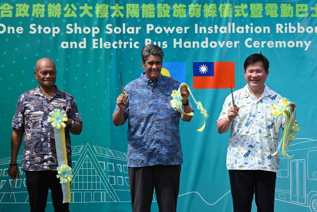 Palau President Surangel S. Whipps Jr. (C) and Taiwan's Foreign Minister Lin Chia-lung (R) cut a ribbon during the inauguration ceremony for Taiwan-funded solar energy and electric bus projects in Koror on August 30, 2026, ahead of the 55th Pacific Islands Forum Leaders Meeting. (Photo by SAEED KHAN / AFP)