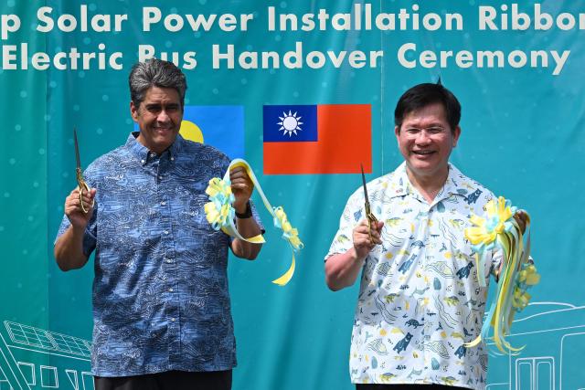 Palau President Surangel S. Whipps Jr. (L) and Taiwan's Foreign Minister Lin Chia-lung gesture after cutting a ribbon during the inauguration ceremony for Taiwan-funded solar energy and electric bus projects in Koror on August 30, 2026, ahead of the 55th Pacific Islands Forum Leaders Meeting. (Photo by SAEED KHAN / AFP)