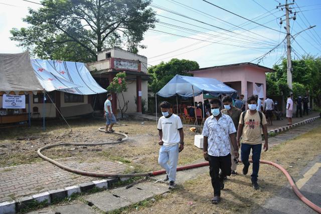Relatives of missing people walk past enquiry tents outside a morgue in Bharatpur, Chitwan on August 30, 2026, after catastrophic flooding in the Nepal-Tibet border. The number of people missing in the catastrophic flood that sliced through the border area between Nepal and Tibet neared 3,000 on August 30, as rescuers scoured deep, leg-sucking mud for survivors. (Photo by PRAKASH MATHEMA / AFP)
