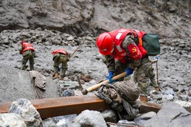 Rescue officers and paramilitary police of the Shigatse Detachment of the Tibet Armed Police Corps, in coordination with heavy machinery, carry out search and rescue and dredging work along one side of the river at the disaster site in Gyirong County, Shigatse, Tibet Autonomous Region, on August 29, 2026. (Photo by CNS / AFP) / China OUT