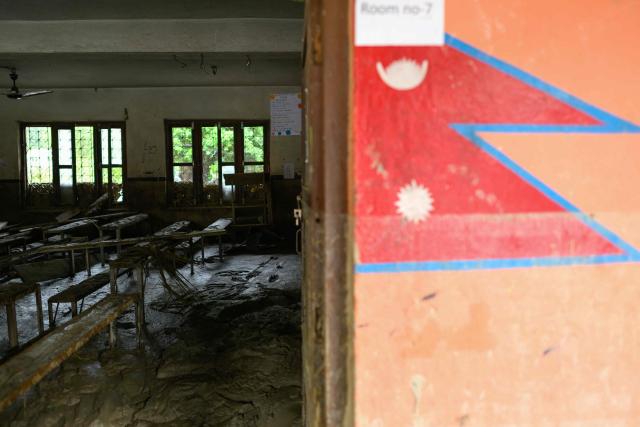 School benches are seen inside a classroom heavily covered in mud in the aftermath of flash floods at Bageshwori Secondary School in Galchi town of Nepal's Dhading district on August 30, 2026. The number of people missing in the catastrophic flood that sliced through the border area between Nepal and Tibet exceeded 3,000 on August 30, as rescuers scoured deep, leg-sucking mud for survivors. (Photo by Manan VATSYAYANA / AFP)