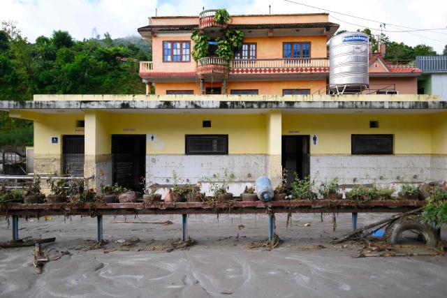 A general view shows pupil's toilets at the Bageshwori secondary school complex covered heavily in mud in the aftermath of flash floods in Galchi town of Nepal's Dhading district on August 30, 2026. The number of people missing in the catastrophic flood that sliced through the border area between Nepal and Tibet exceeded 3,000 on August 30, as rescuers scoured deep, leg-sucking mud for survivors. (Photo by Manan VATSYAYANA / AFP)