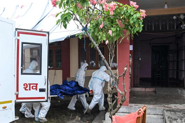 Health workers carry a dead body inside a mortuary in the aftermath of flash floods, in Bharatpur of Nepal's Chitwan district on August 30, 2026. The number of people missing in the catastrophic flood that sliced through the border area between Nepal and Tibet neared 3,000 on August 30, as rescuers scoured deep, leg-sucking mud for survivors. (Photo by Prakash MATHEMA / AFP)