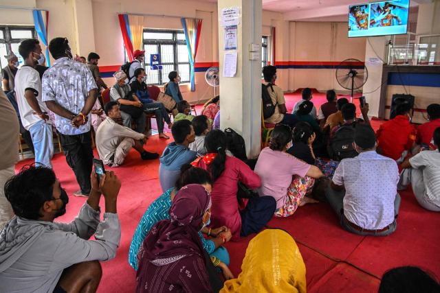 Family members watch a screen displaying identities of victims at a mortuary in the aftermath of flash floods, in Bharatpur of Nepal's Chitwan district on August 30, 2026. The number of people missing in the catastrophic flood that sliced through the border area between Nepal and Tibet neared 3,000 on August 30, as rescuers scoured deep, leg-sucking mud for survivors. (Photo by Prakash MATHEMA / AFP)