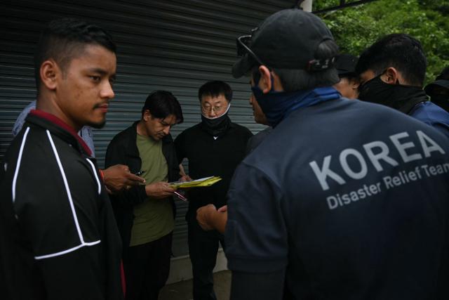 Members of the Korea Disaster Relief Team (KDRT) gather at the Trishuli Center to inspect the affected area in the aftermath of flash floods in Nepal's Nuwakot district on August 30, 2026. The number of people missing in the catastrophic flood that sliced through the border area between Nepal and Tibet neared 3,000 on August 30, as rescuers scoured deep, leg-sucking mud for survivors. (Photo by Arun SANKAR / AFP)
