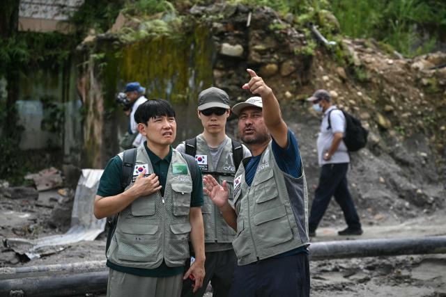 Members of the Korea Food for the Hungry International (KFHI) inspect the affected area at the Trishuli Center in the aftermath of flash floods in Nepal's Nuwakot district on August 30, 2026. The number of people missing in the catastrophic flood that sliced through the border area between Nepal and Tibet neared 3,000 on August 30, as rescuers scoured deep, leg-sucking mud for survivors. (Photo by Arun SANKAR / AFP)