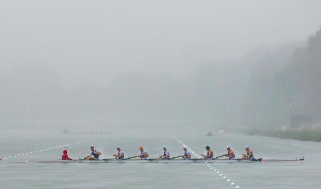 TOPSHOT - Competitors row in heavy rainfall on the seventh day of the World Rowing Championships at the Bosbaan in  Amsterdam on August 30, 2026. (Photo by Iris van den Broek / ANP / AFP) / Netherlands OUT