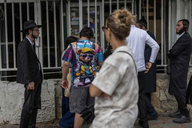 Ultra-Orthodox Jewish men wait with others outside an Israeli military recruitment centre during a military draft call-up day, in Jerusalem on August 30, 2026. (Photo by ilia YEFIMOVICH / AFP)