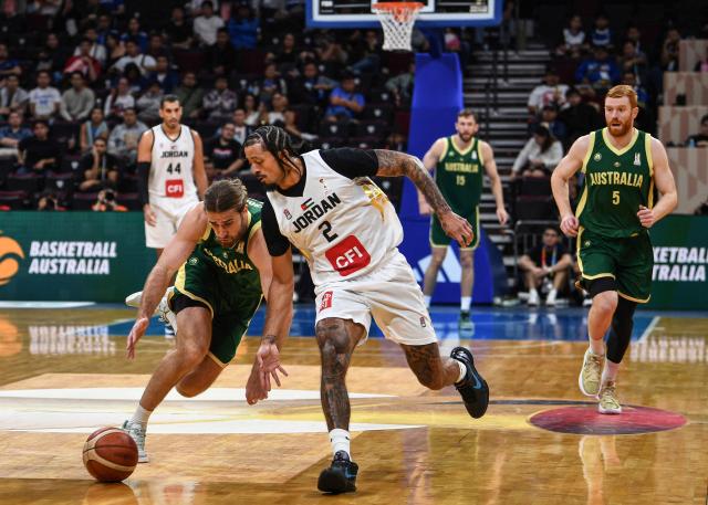 Australia's Sam Froling (L) fights for the ball with Jordan's Jalen Harris during their 2027 FIBA Basketball World Cup Asian qualifier group E match at the Mall of Asia Arena in Pasay city, Metro Manila on August 30, 2026. (Photo by Ted ALJIBE / AFP)