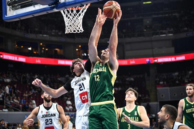 Australia's Josh Bannan (C) rebounds against Jordan's Hadi Ammar Alshami (centre L) during their 2027 FIBA Basketball World Cup Asian qualifier group E match at the Mall of Asia Arena in Pasay city, Metro Manila on August 30, 2026. (Photo by Ted ALJIBE / AFP)