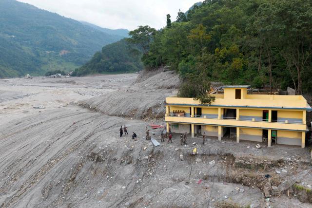 An aerial view shows security personnel conducting a rescue operation in the aftermath of flash floods, along the Trishuli river at Betrawati in Nepal's Nuwakot district on August 29, 2026. More than 3,000 people were listed as missing on August 30, with another 768 confirmed dead, after the flash floods and landslides that hit the Nepal-Tibet border. (Photo by Prabin RANABHAT / AFP)