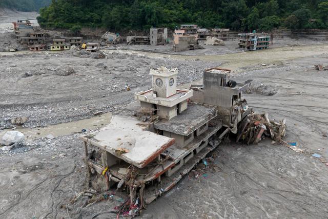 An aerial view shows damaged building in the aftermath of flash floods, near Trishuli river at Betrawati in Nepal's Nuwakot district on August 29, 2026. More than 3,000 people were listed as missing on August 30, with another 768 confirmed dead, after the flash floods and landslides that hit the Nepal-Tibet border. (Photo by Prabin RANABHAT / AFP)