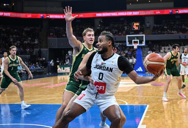 Jordan's Abdullah Olajuwon (R) controls the ball as Australia's Jacob Holt (L) attempts to block during their 2027 FIBA Basketball World Cup Asian qualifier group E match at the Mall of Asia Arena in Pasay city, Metro Manila on August 30, 2026. (Photo by Ted ALJIBE / AFP)