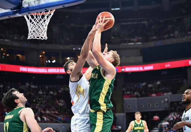 Australia's Jacob Holt (centre R) rebounds for the ball with Jordan's Saif Al-Deen Saleh (centre L) during their 2027 FIBA Basketball World Cup Asian qualifier group E match at the Mall of Asia Arena in Pasay city, Metro Manila on August 30, 2026. (Photo by Ted ALJIBE / AFP)