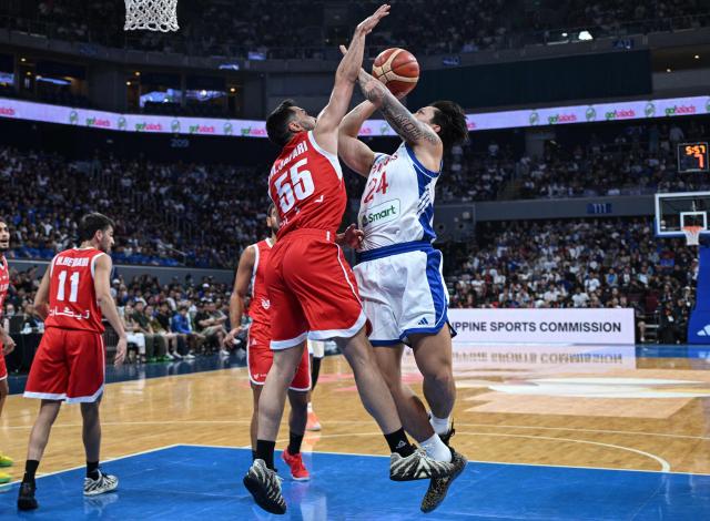 Iran's Seyed Mahdi Jafari (centre L) blocks a shot by Philippines' Dwight Ramos (centre R) during their 2027 FIBA Basketball World Cup Asian qualifier group E match at the Mall of Asia Arena in Pasay city, Metro Manila on August 30, 2026. (Photo by Ted ALJIBE / AFP)