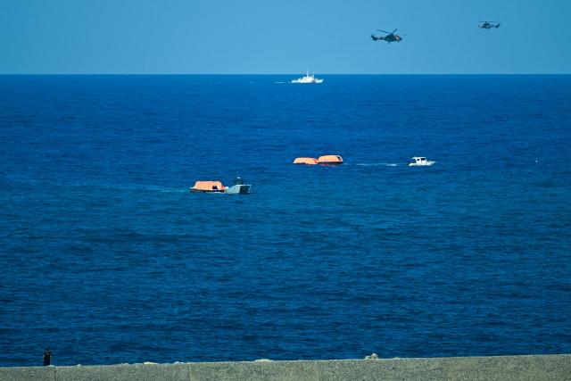 Turkish vessels and helicopters search the waters during a rescue operation off the coast of Kyrenia, in the self-proclaimed Turkish Republic of Northern Cyprus (TRNC), recognised only by Turkey, on August 30, 2026, after a ferry capsized. A passenger ferry capsized and sank off Northern Cyprus on August 30, killing at least seven people and leaving 23 missing, officials said, as a rescue operation was under way. The cause was not yet established. But one rescued passenger told local media a blast went off at the bow of the ferry before it rolled over. (Photo by Jewel SAMAD / AFP)
