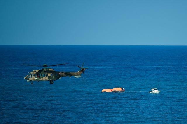 A Turkish helicopter searches the waters during a rescue operation off the coast of Kyrenia, in the self-proclaimed Turkish Republic of Northern Cyprus (TRNC), recognised only by Turkey, on August 30, 2026, after a ferry capsized. A passenger ferry capsized and sank off Northern Cyprus on August 30, killing at least seven people and leaving 23 missing, officials said, as a rescue operation was under way. The cause was not yet established. But one rescued passenger told local media a blast went off at the bow of the ferry before it rolled over. (Photo by Jewel SAMAD / AFP)