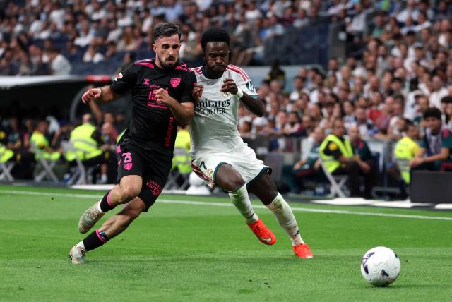 Malaga's Spanish defender #03 Carlos Puga and Real Madrid's Brazilian forward #07 Vinicius Junior fight for the ball during the Spanish league football match between Real Madrid CF and Malaga CF at Santiago Bernabeu Stadium in Madrid on August 30, 2026. (Photo by Thomas COEX / AFP)