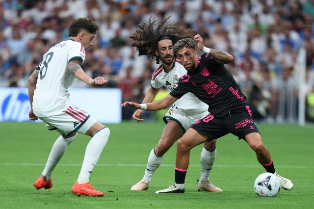 Real Madrid's Uruguayan midfielder #08 Federico Valverde and Real Madrid's Spanish defender #17 Marc Cucurella fight for the ball with Malaga's Spanish forward #10 David Larrubia during the Spanish league football match between Real Madrid CF and Malaga CF at Santiago Bernabeu Stadium in Madrid on August 30, 2026. (Photo by Thomas COEX / AFP)