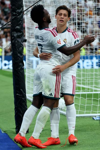 Real Madrid's Turkish midfielder #15 Arda Guler celebrates with his teammate Real Madrid's Brazilian forward #07 Vinicius Junior after scoring his team's fourth goal during the Spanish league football match between Real Madrid CF and Malaga CF at Santiago Bernabeu Stadium in Madrid on August 30, 2026. (Photo by Thomas COEX / AFP)