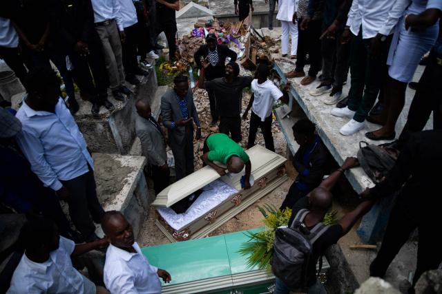 A man closes a coffin before burial during a collective funeral for more than twenty people killed by armed gangs last week in Kenscoff, a neighborhood near Port-au-Prince, on August 30, 2026. Gang members attacked displaced people huddling inside a church near Haiti's capital, killing around 40, some of them execution-style, the mayor told AFP on August 24. (Photo by Clarens SIFFROY / AFP)