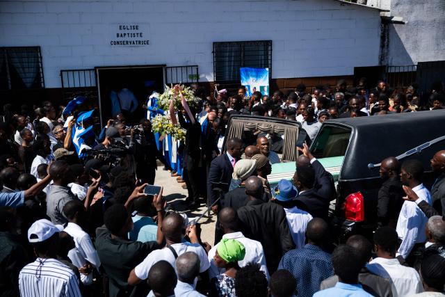 A coffin is put  into a hearse during a collective funeral service for more than twenty people killed by armed gangs last week in Kenscoff, a neighborhood near Port-au-Prince, on August 30, 2026. Gang members attacked displaced people huddling inside a church near Haiti's capital, killing around 40, some of them execution-style, the mayor told AFP on August 24. (Photo by Clarens SIFFROY / AFP)
